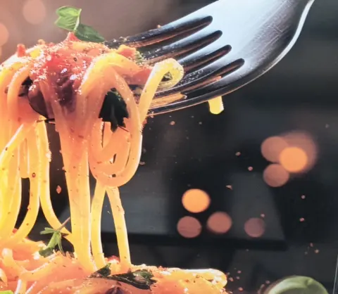Spaghetti à la sauce tomate enroulés sur une fourchette, affiche du restaurant